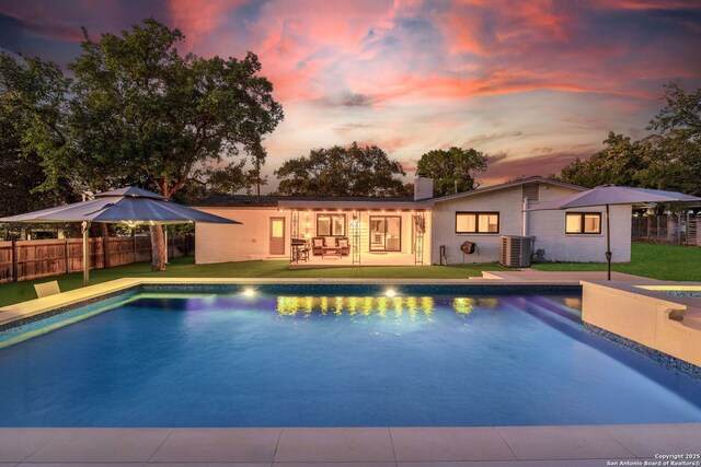 back of property with a chimney, central AC unit, a patio, and brick siding
