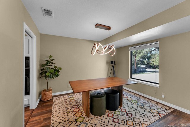 office space featuring wood finished floors, baseboards, and a chandelier