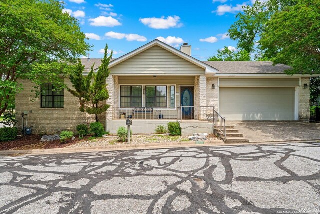 239 Old Oaks, Kerrville, TX 78028 - single story home with brick siding, a garage, covered porch, a chimney, and concrete driveway