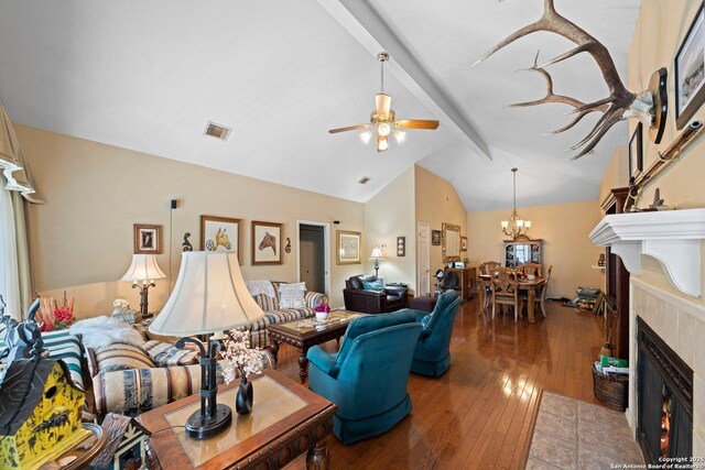 239 Old Oaks, Kerrville, TX 78028 - living room featuring beamed ceiling, a tiled fireplace, ceiling fan, hardwood / wood-style flooring, and a chandelier