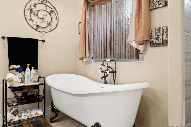 bathroom with a freestanding tub and baseboards