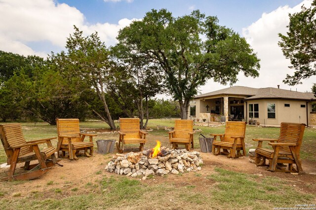 view of grassy yard featuring an outdoor fire pit