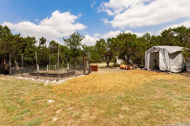 view of green lawn with a shed and an outbuilding