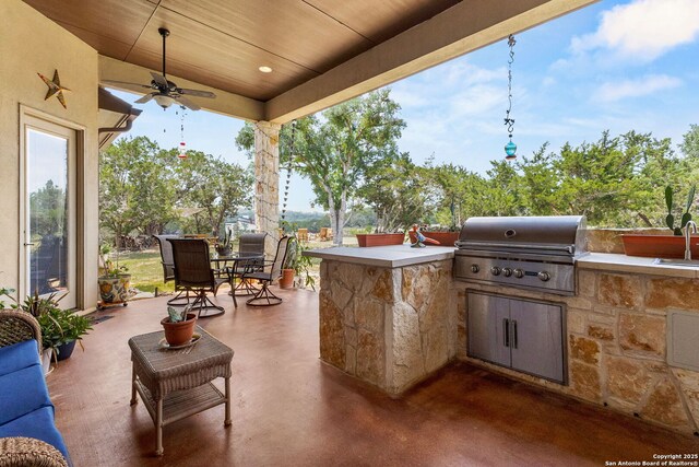 view of patio featuring a grill, an outdoor kitchen, outdoor dining area, ceiling fan, and a sink