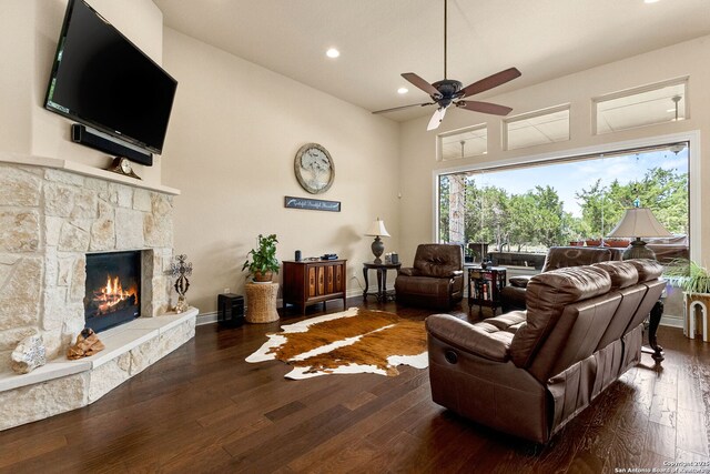 living room featuring ceiling fan, wood-type flooring, a stone fireplace, and recessed lighting