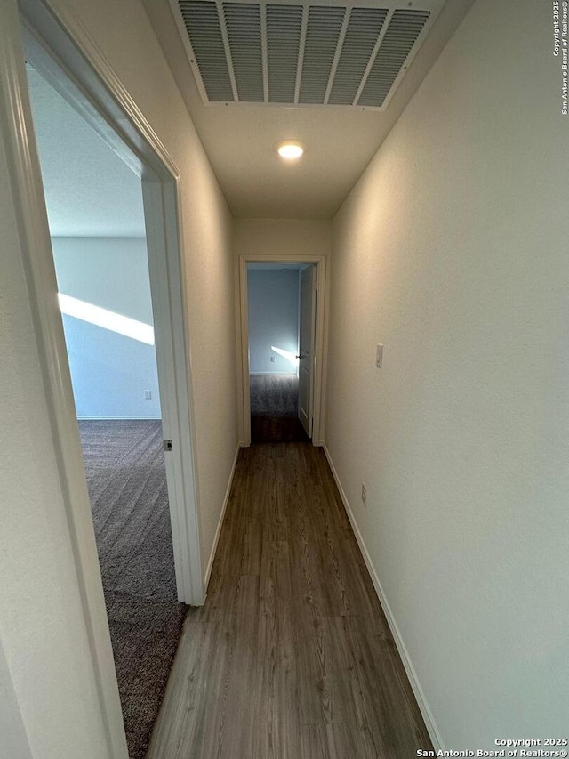 hall featuring baseboards and wood finished floors