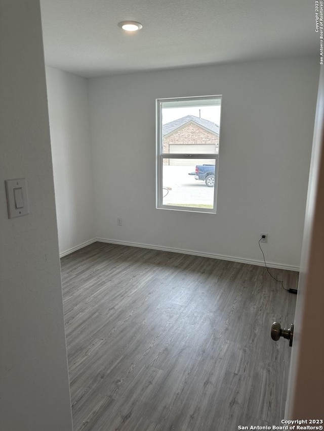 empty room with wood finished floors and baseboards