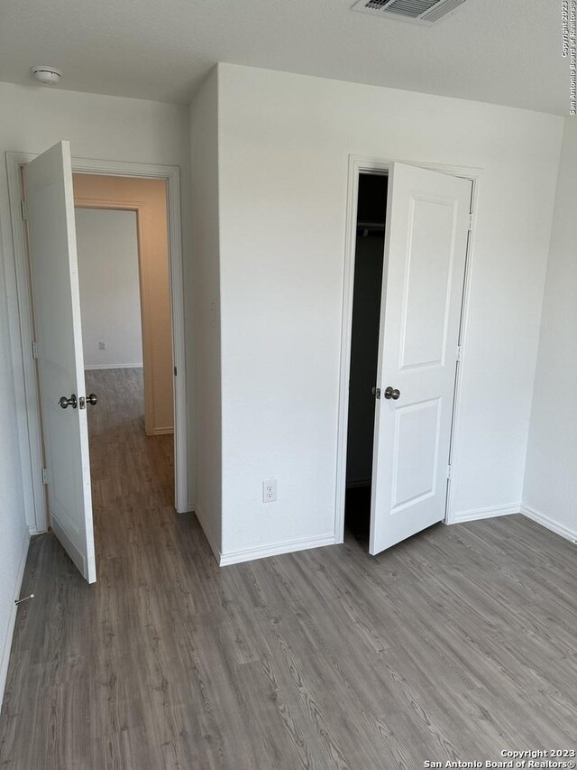 10742 Hernando Ct, Converse, TX 78109 - unfurnished bedroom with wood finished floors, baseboards, and a closet