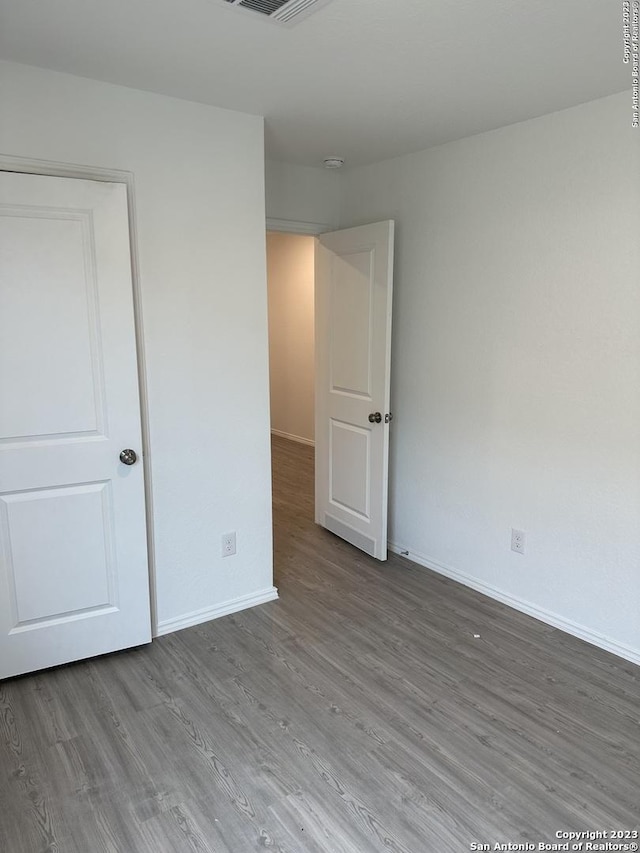 empty room featuring wood finished floors and baseboards