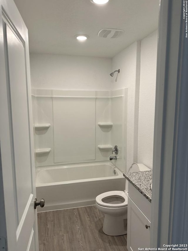 full bath with wood finished floors, toilet, shower / tub combination, and vanity