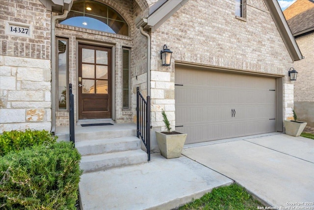 14327 Running Wolf, San Antonio, TX 78245 - entrance to property featuring an attached garage, stone siding, concrete driveway, and brick siding