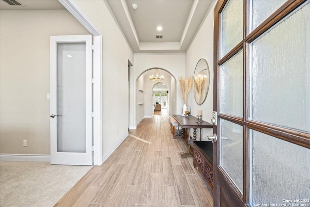 14327 Running Wolf, San Antonio, TX 78245 - hall featuring light wood-style floors, arched walkways, baseboards, and a chandelier