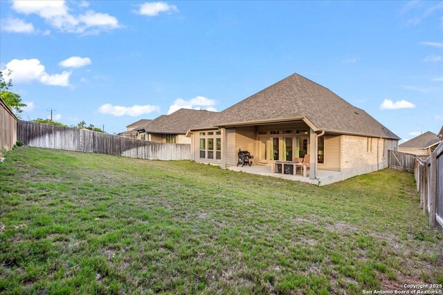 back of house with a patio and a shingled roof