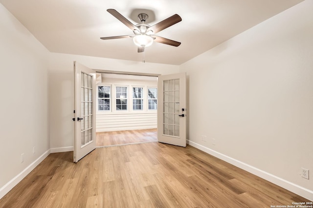 empty room with french doors, baseboards, a ceiling fan, and light wood-style flooring