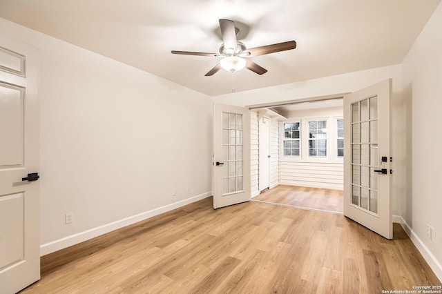 spare room with french doors, a ceiling fan, and baseboards