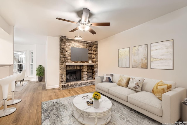 living room with ceiling fan, wood finished floors, and a fireplace