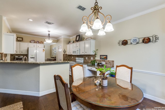9347 Llano Verde, Helotes, TX 78023 - dining area with dark wood-style flooring, crown molding, a chandelier, and baseboards