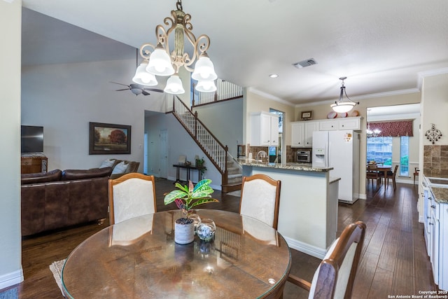9347 Llano Verde, Helotes, TX 78023 - dining area with a chandelier, dark wood finished floors, ornamental molding, stairs, and baseboards