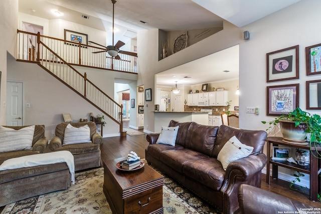 9347 Llano Verde, Helotes, TX 78023 - living room featuring ceiling fan, hardwood / wood-style flooring, stairs, a towering ceiling, and baseboards