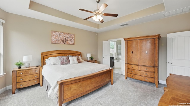 3318 Jasons, Marion, TX 78124 - bedroom featuring a tray ceiling, light carpet, baseboards, ensuite bathroom, and ceiling fan