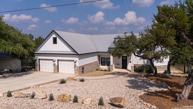 modern inspired farmhouse with brick siding, driveway, metal roof, fence, and a standing seam roof
