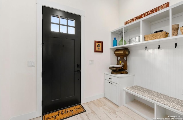 mudroom featuring baseboards and light wood finished floors