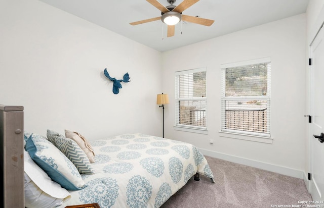 carpeted bedroom featuring baseboards and a ceiling fan