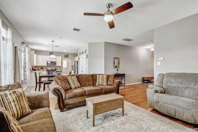 141 Glen Eagles, Cibolo, TX 78108 - living area featuring ceiling fan, light wood-style floors, and baseboards