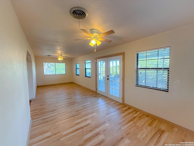 3084 Rustler, Canyon Lake, TX 78133 - spare room with french doors, light wood-style floors, a ceiling fan, and baseboards