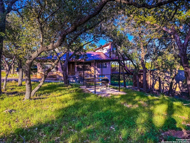 3084 Rustler, Canyon Lake, TX 78133 - rear view of property featuring a patio area, metal roof, and a lawn
