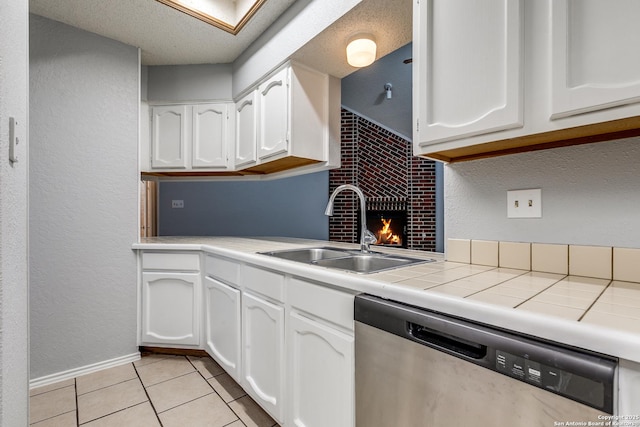 5615 Timber Bark, San Antonio, TX 78250 - kitchen with stainless steel dishwasher, a sink, white cabinetry, tile counters, and light tile patterned floors