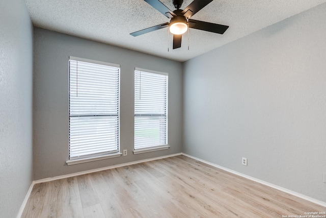 5615 Timber Bark, San Antonio, TX 78250 - spare room featuring light wood-style floors, ceiling fan, baseboards, and a textured ceiling