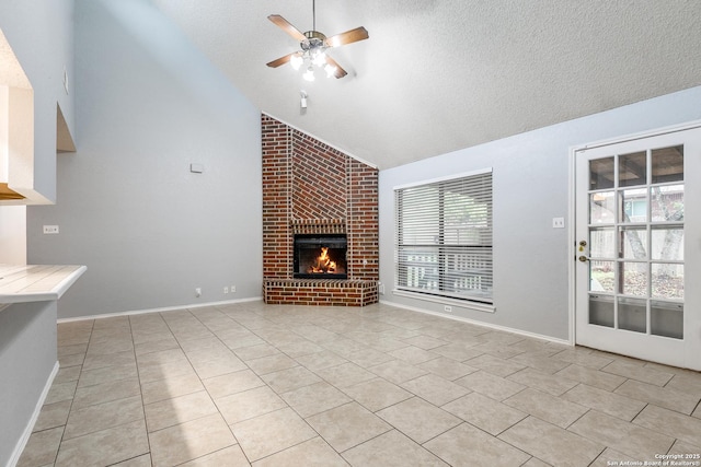 5615 Timber Bark, San Antonio, TX 78250 - unfurnished living room featuring vaulted ceiling, light tile patterned floors, a textured ceiling, a ceiling fan, and a brick fireplace