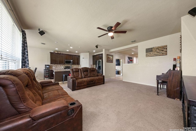 living area featuring ceiling fan, light colored carpet, recessed lighting, baseboards, and a textured ceiling