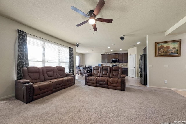 living room featuring light colored carpet, a ceiling fan, a textured ceiling, baseboards, and recessed lighting