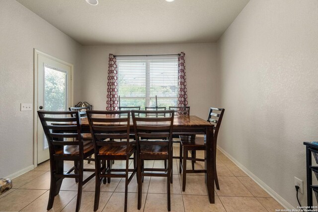 dining room with light tile patterned floors and baseboards