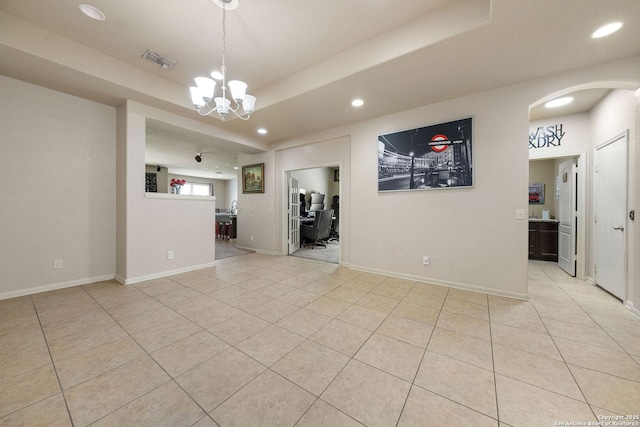 empty room with recessed lighting, arched walkways, light tile patterned floors, a chandelier, and baseboards