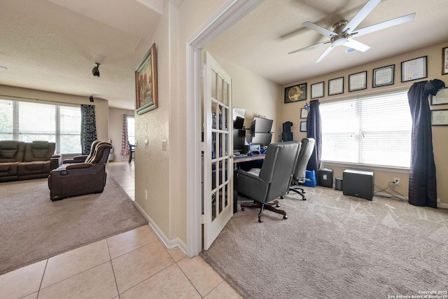 carpeted home office with a ceiling fan, tile patterned flooring, and a textured ceiling