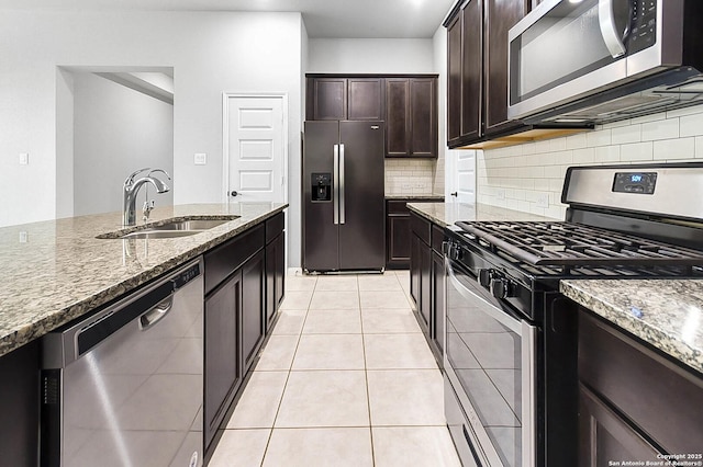 12466 Belfort Pt, Schertz, TX 78154 - kitchen featuring appliances with stainless steel finishes, a sink, stone countertops, decorative backsplash, and light tile patterned floors