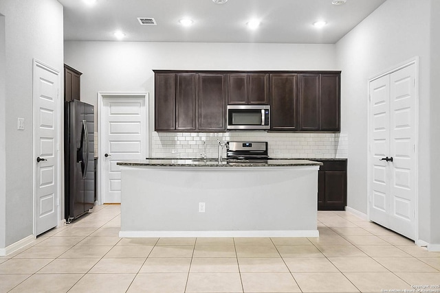 12466 Belfort Pt, Schertz, TX 78154 - kitchen with appliances with stainless steel finishes, backsplash, dark brown cabinets, a center island with sink, and recessed lighting