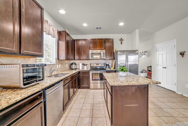 3628 Lazy Diamond, Selma, TX 78154 - kitchen featuring stainless steel appliances, a sink, a center island, tasteful backsplash, and light stone counters