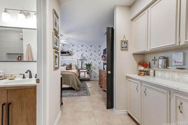 7500 Callaghan Rd Unit 108, San Antonio, TX 78229 - bedroom with a sink, light tile patterned floors, baseboards, and wallpapered walls