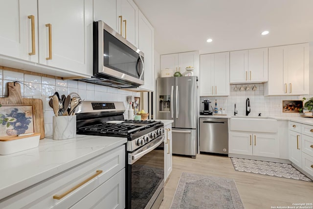 7500 Callaghan Rd Unit 108, San Antonio, TX 78229 - kitchen with appliances with stainless steel finishes, a sink, backsplash, white cabinets, and recessed lighting