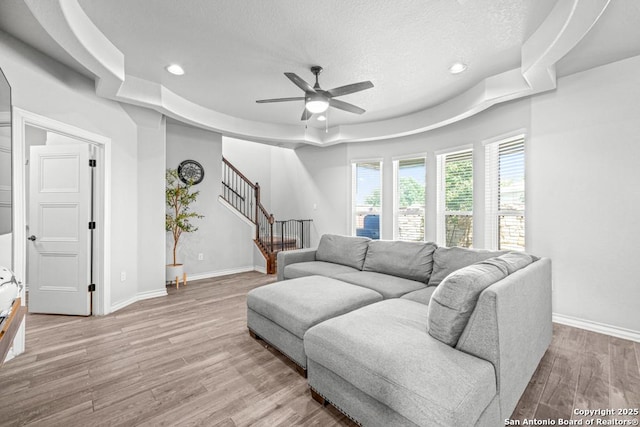 8502 Kallison Arbor, San Antonio, TX 78254 - living area with a raised ceiling, ceiling fan, stairs, light wood-style flooring, and recessed lighting