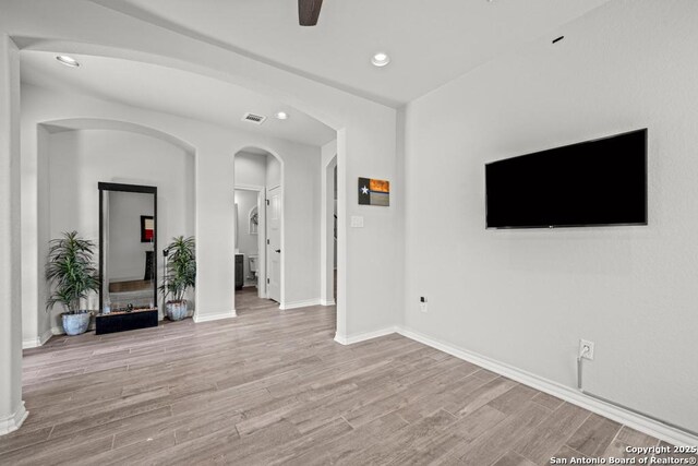 8502 Kallison Arbor, San Antonio, TX 78254 - unfurnished living room with light wood-style flooring, recessed lighting, arched walkways, a ceiling fan, and baseboards