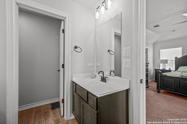 8502 Kallison Arbor, San Antonio, TX 78254 - bathroom featuring a textured ceiling, vanity, baseboards, and lofted ceiling