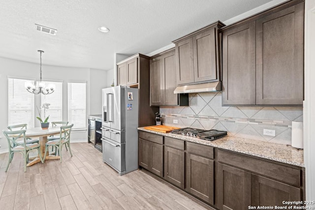 8502 Kallison Arbor, San Antonio, TX 78254 - kitchen featuring appliances with stainless steel finishes, under cabinet range hood, backsplash, light wood finished floors, and a chandelier