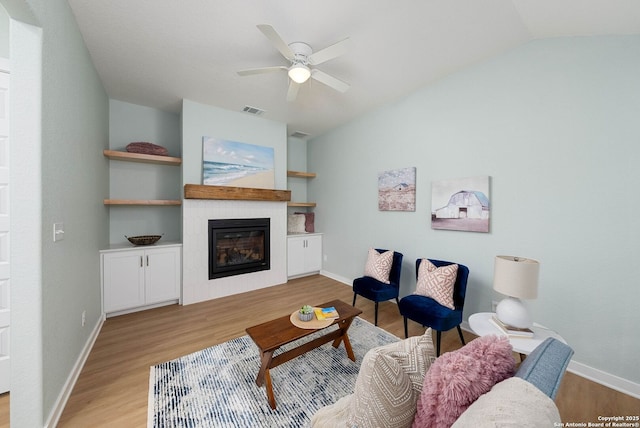 2230 Bennett Ave, New Braunfels, TX 78132 - living room featuring light wood-style floors, a glass covered fireplace, vaulted ceiling, ceiling fan, and baseboards