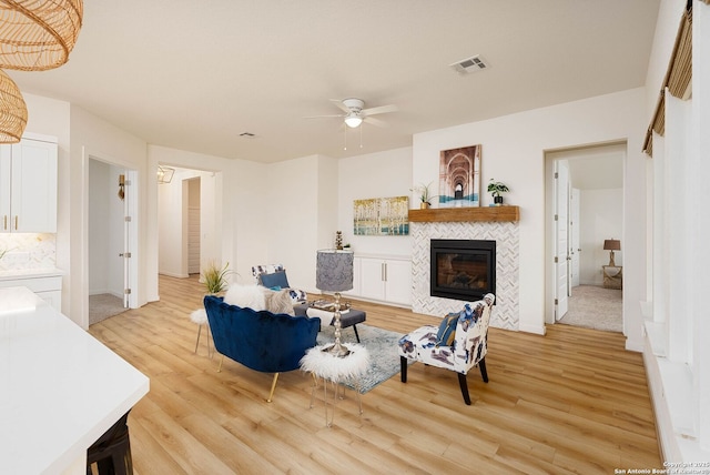 2230 Bennett Ave, New Braunfels, TX 78132 - living area with a ceiling fan, light wood-style flooring, a tile fireplace, and baseboards