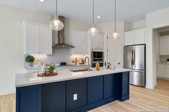 1310 S Mesquite, San Antonio, TX 78210 - kitchen with freestanding refrigerator, wall chimney exhaust hood, a sink, white cabinets, and recessed lighting